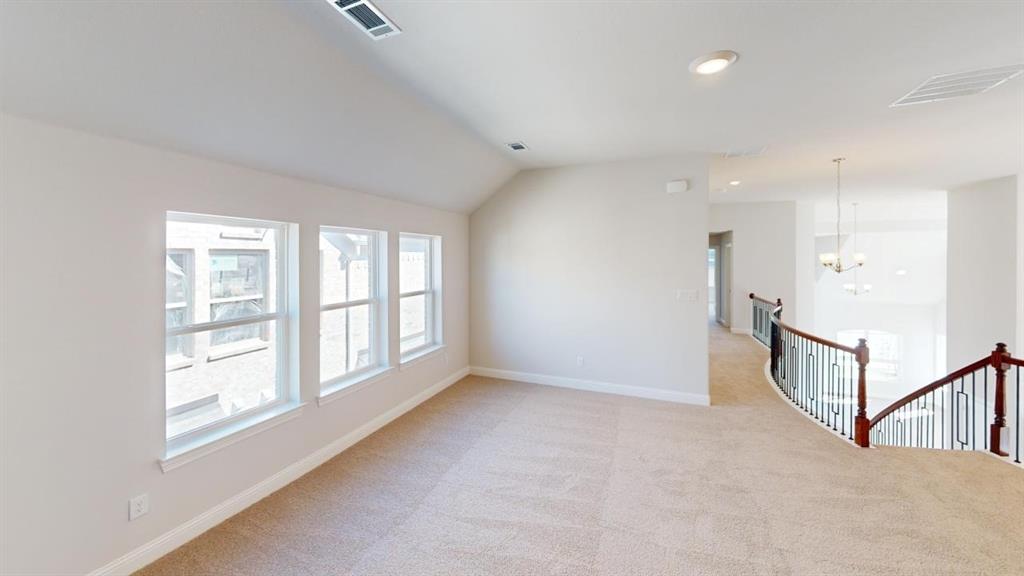 8407 Cornerstone Drive Rowlett, TX 75088 - Photo 19 of 25 Spacious upper-level loft featuring three double-hung windows, vaulted ceilings, recessed lighting, and soft carpet flooring