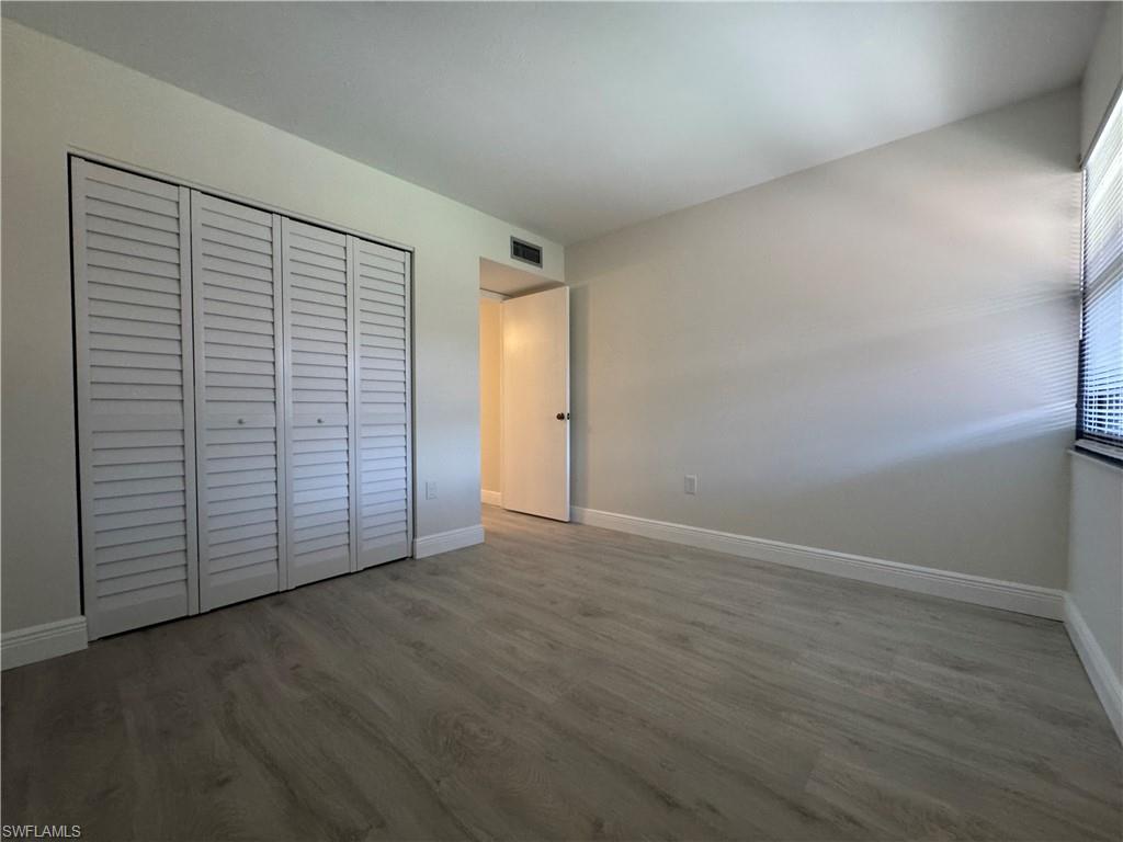 1530 Mainsail Drive, Unit 11 Naples, FL 34114 - Photo 17 of 26 an empty room with wooden floor and closet