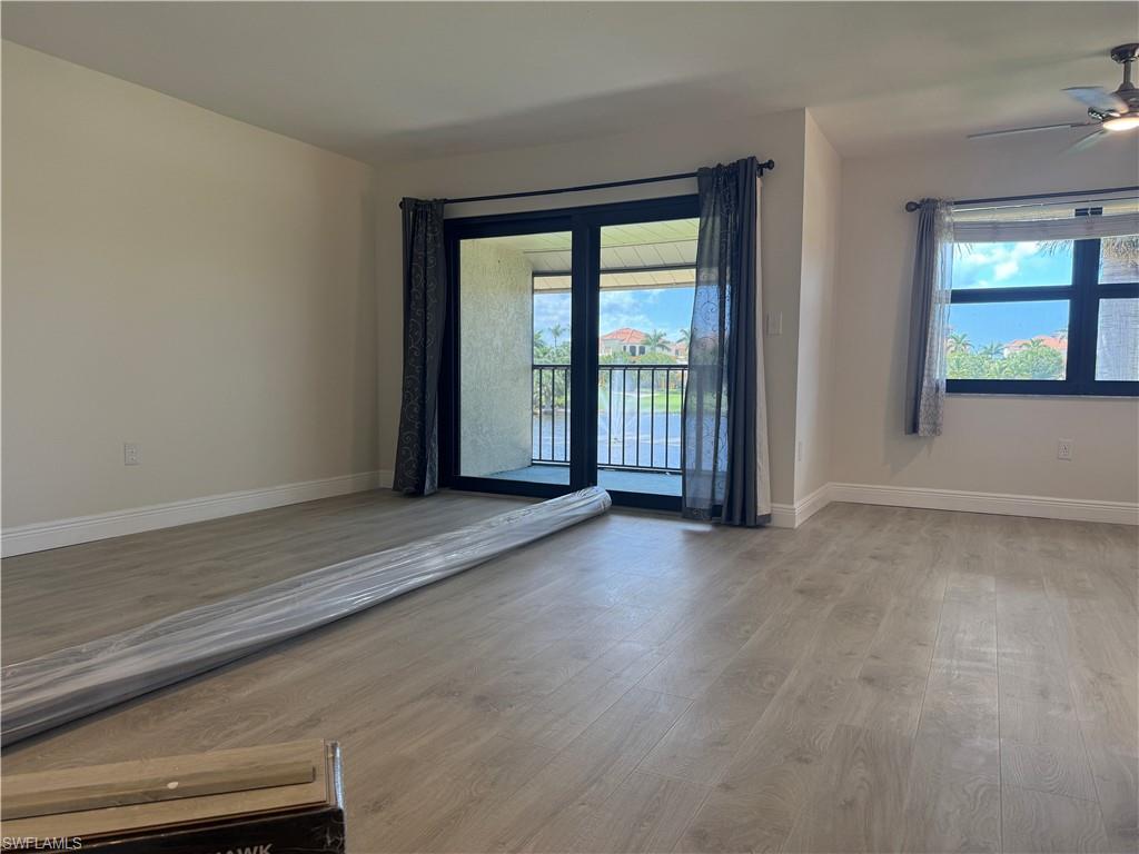 1530 Mainsail Drive, Unit 11 Naples, FL 34114 - Photo 2 of 26 an empty room with wooden floor and windows
