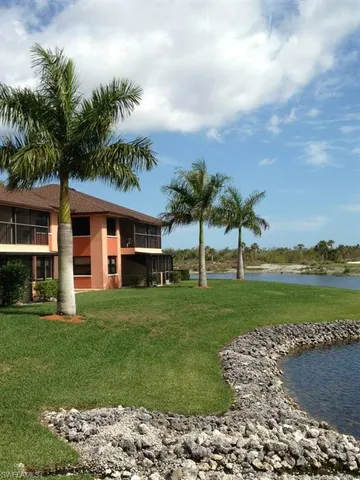 a view of swimming pool with a lawn chairs and palm tree
