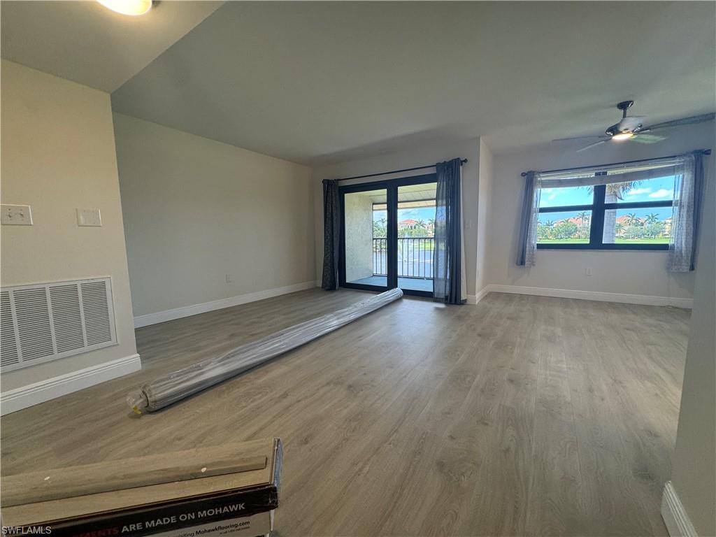 1530 Mainsail Drive, Unit 11 Naples, FL 34114 - Photo 5 of 26 an empty room with wooden floor and windows