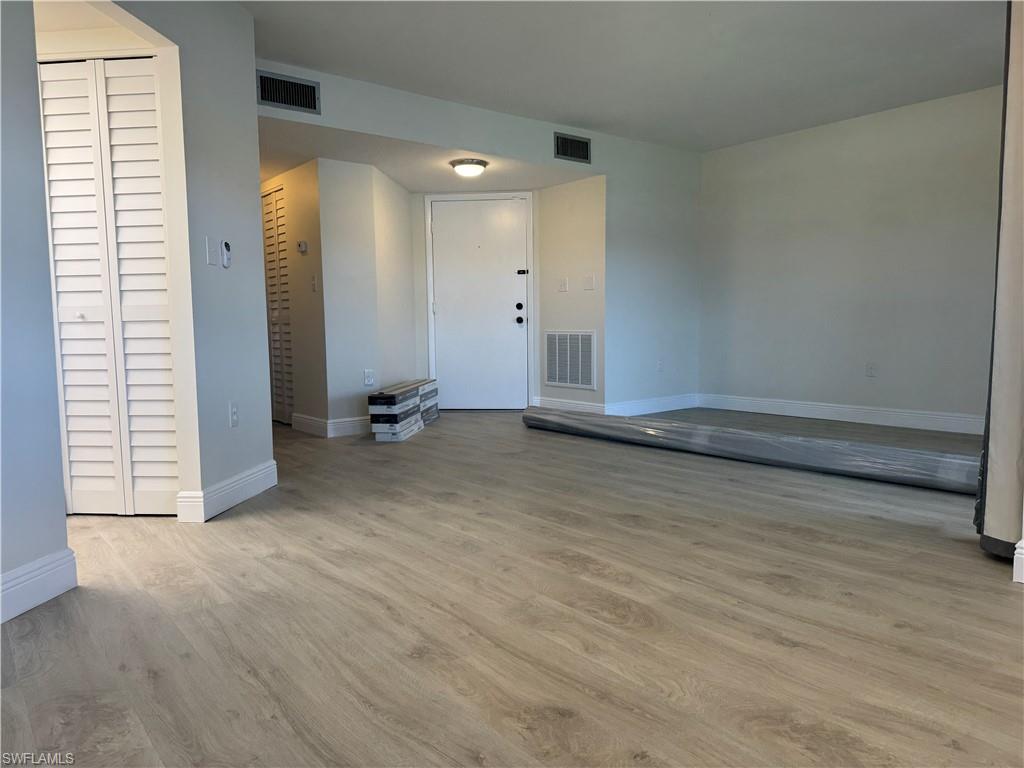1530 Mainsail Drive, Unit 11 Naples, FL 34114 - Photo 7 of 26 an empty room with wooden floor and a window