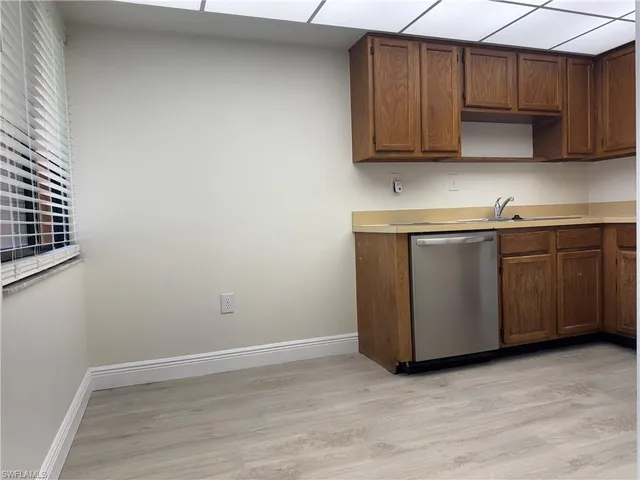 a room with wooden cabinets washer dryer and cabinets