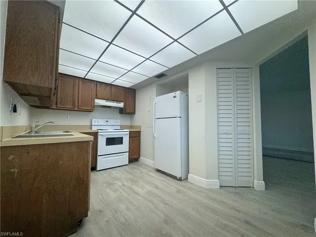 a kitchen with stainless steel appliances granite countertop a sink a stove a refrigerator and cabinets