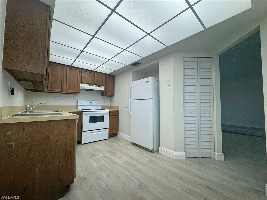 1530 Mainsail Drive, Unit 11 Naples, FL 34114 - Photo 10 of 26 a kitchen with stainless steel appliances granite countertop a sink a stove a refrigerator and cabinets