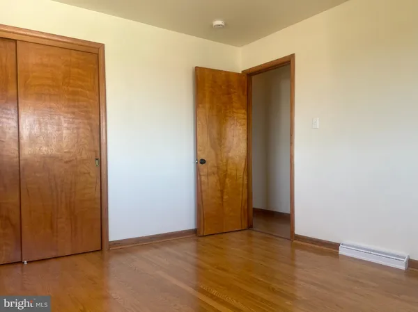 an empty room with wooden floor and a window