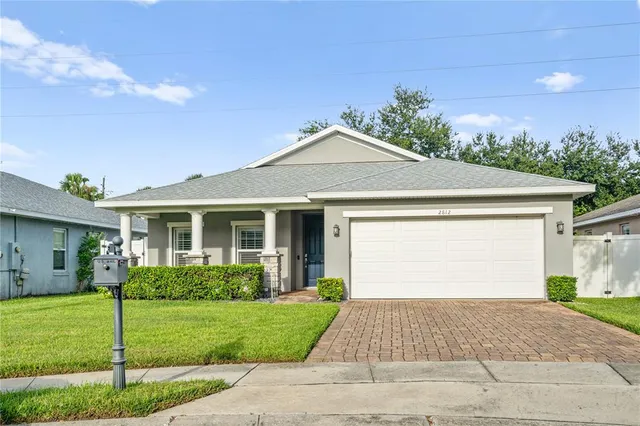 a front view of a house with a yard and potted plants