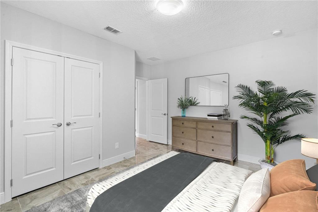 2812 Roseglen Way Orlando, FL 32812 - Photo 14 of 20 a bedroom with a bed and a potted plant