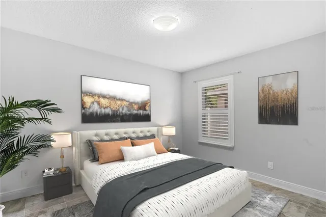 a bedroom with bed and a painting on the wall