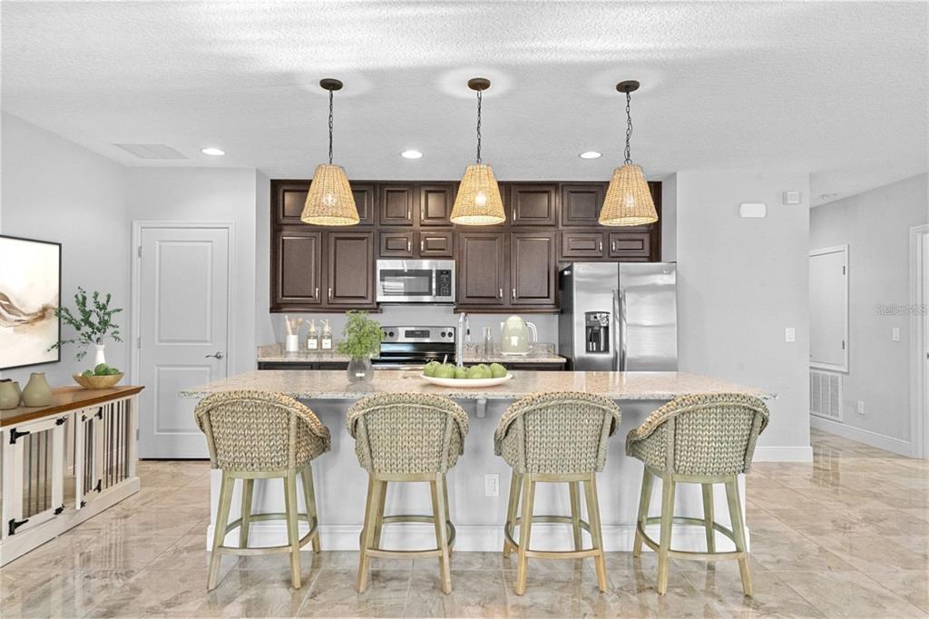 2812 Roseglen Way Orlando, FL 32812 - Photo 2 of 20 a kitchen with stainless steel appliances granite countertop a table chairs and a refrigerator