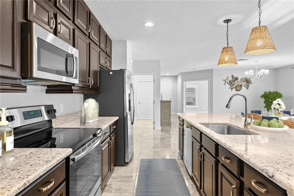 2812 Roseglen Way Orlando, FL 32812 - Photo 3 of 20 a kitchen with stainless steel appliances granite countertop a sink a stove and a refrigerator
