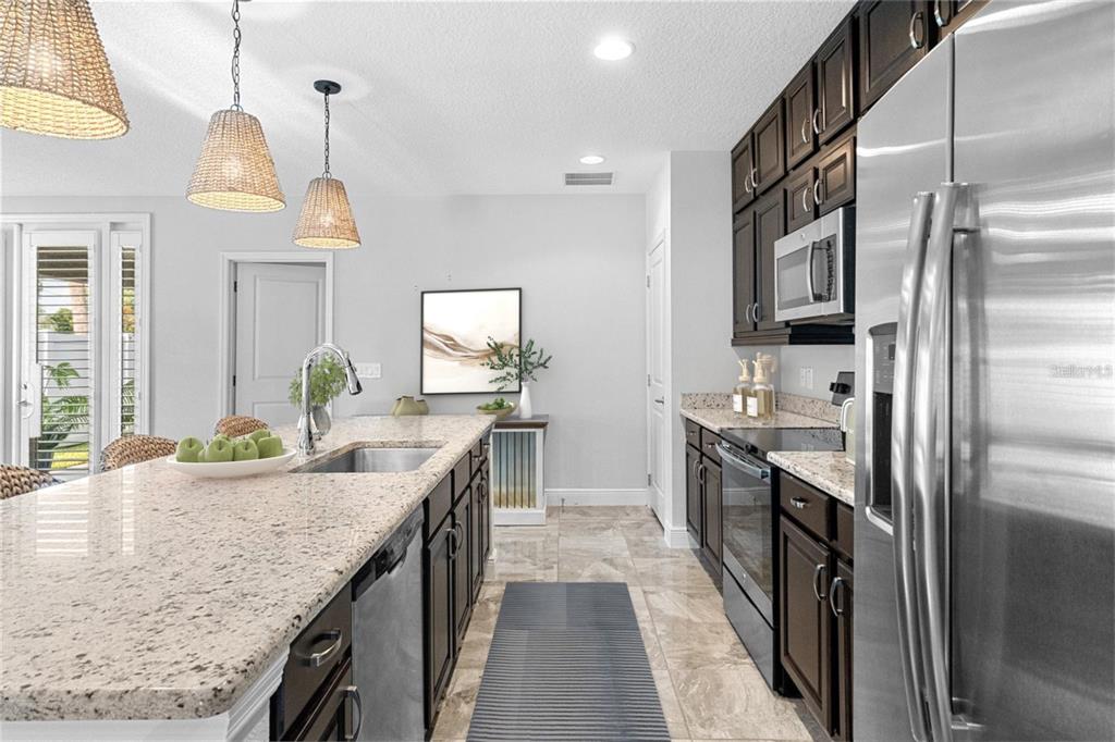 2812 Roseglen Way Orlando, FL 32812 - Photo 4 of 20 a kitchen with stainless steel appliances granite countertop a sink and stove