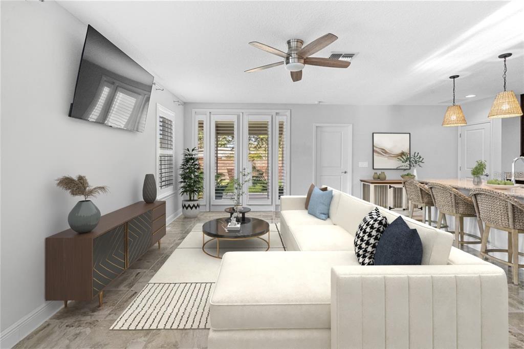 2812 Roseglen Way Orlando, FL 32812 - Photo 5 of 20 a living room with furniture a ceiling fan a flat screen tv and a large window