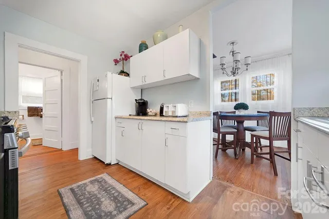 a open kitchen with granite countertop a table and chairs in it