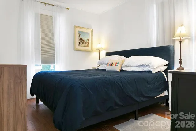 a bedroom with a bed lamp and a mirror