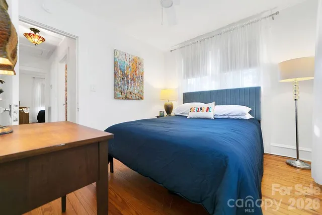 a bedroom with a bed and a lamp on dresser