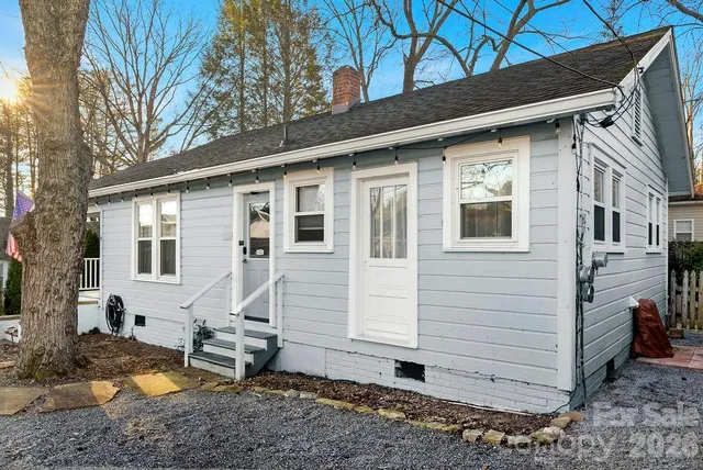 a view of a small house with backyard