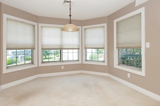 a view of empty room with windows and chandelier