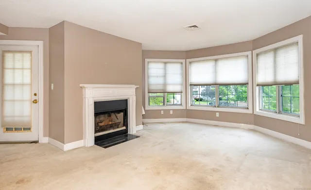 a view of an empty room with a window and a fireplace