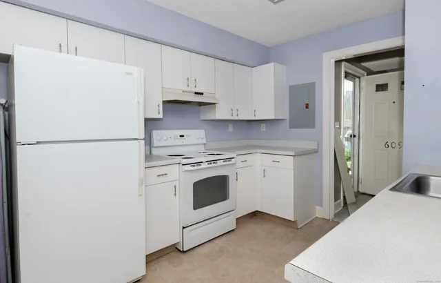 a white refrigerator freezer sitting inside of a kitchen