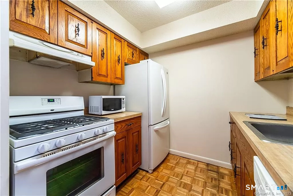 5 Stonegate Circle, Unit F Branford, CT 06405 - Photo 11 of 15 a kitchen with stainless steel appliances granite countertop a stove a refrigerator and a microwave