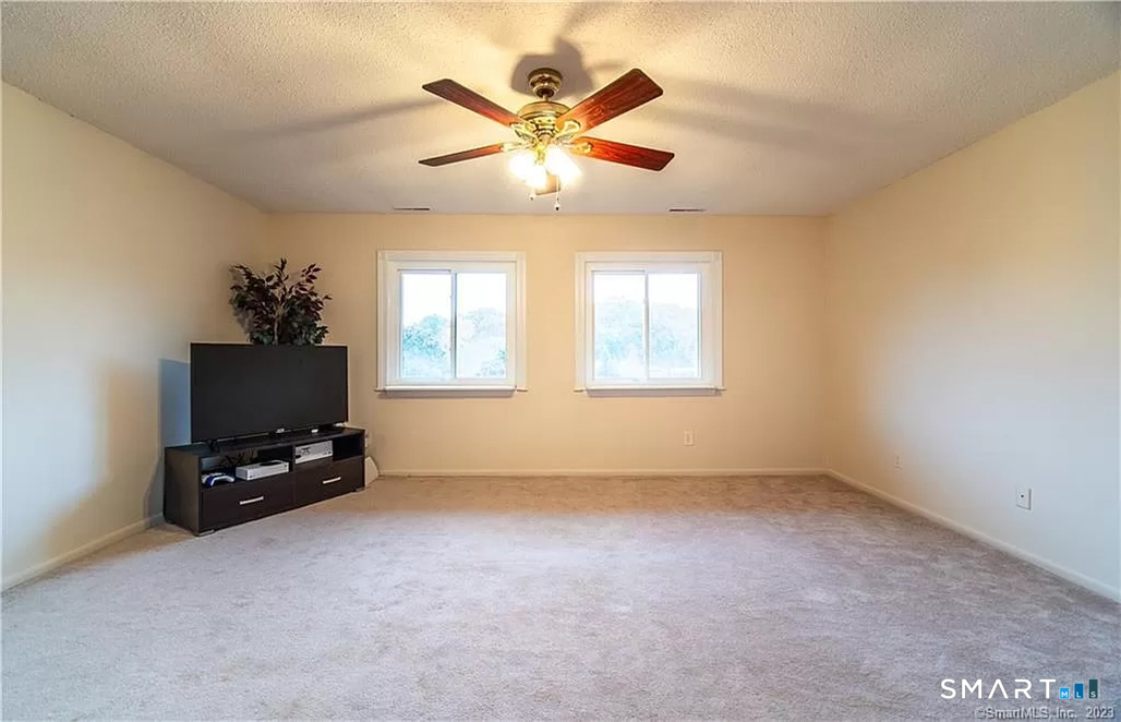 5 Stonegate Circle, Unit F Branford, CT 06405 - Photo 5 of 15 a view of a livingroom with a ceiling fan and a window