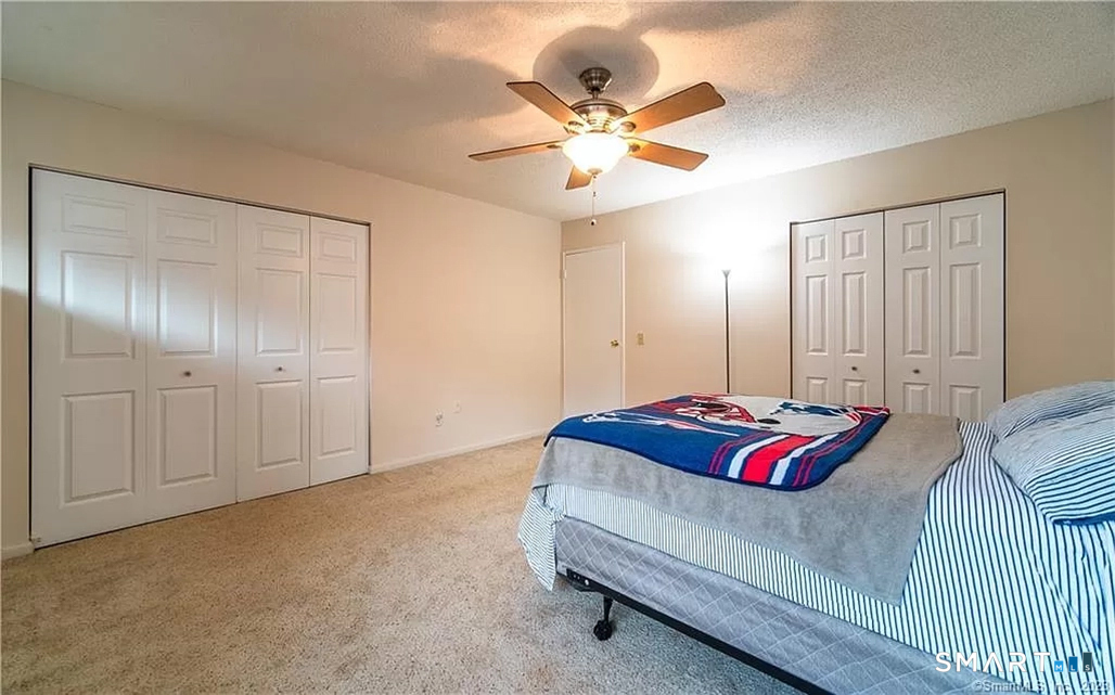 5 Stonegate Circle, Unit F Branford, CT 06405 - Photo 9 of 15 a bedroom with a bed and a chandelier