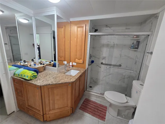 a bathroom with a granite countertop sink a mirror and a toilet