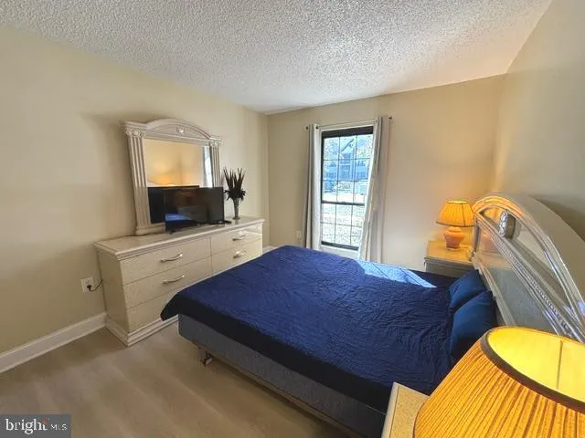 a bedroom with a bed and flat tv screen on the dresser