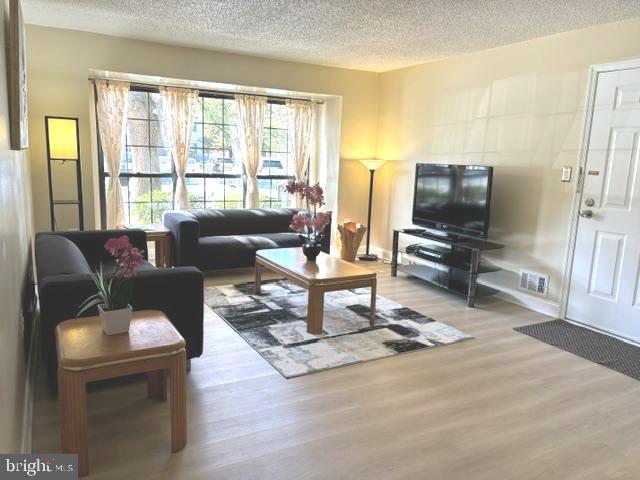 27 Gilpin Court Lawrence Township, NJ 08648 - Photo 2 of 20 a living room with furniture a flat screen tv and a large window