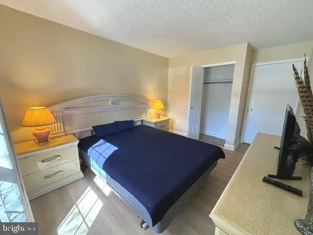 a room with a bed and a flat tv screen on dresser