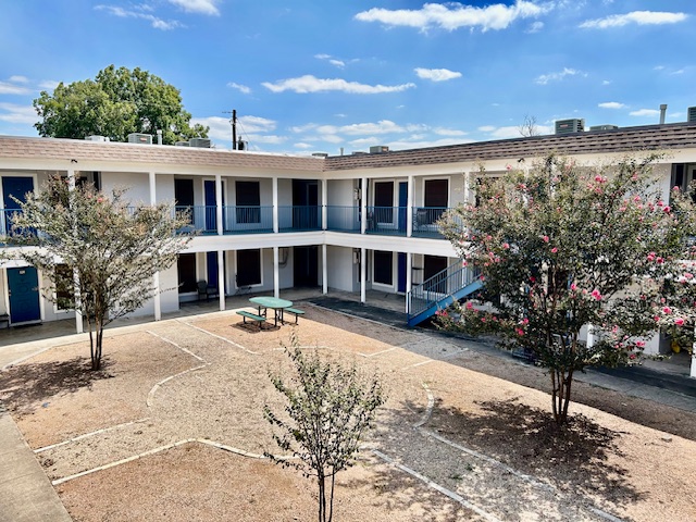a view of a house with backyard and sitting area