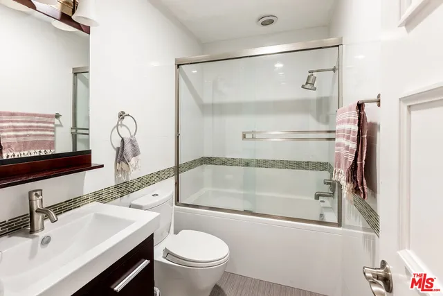 a bathroom with a sink mirror vanity and toilet