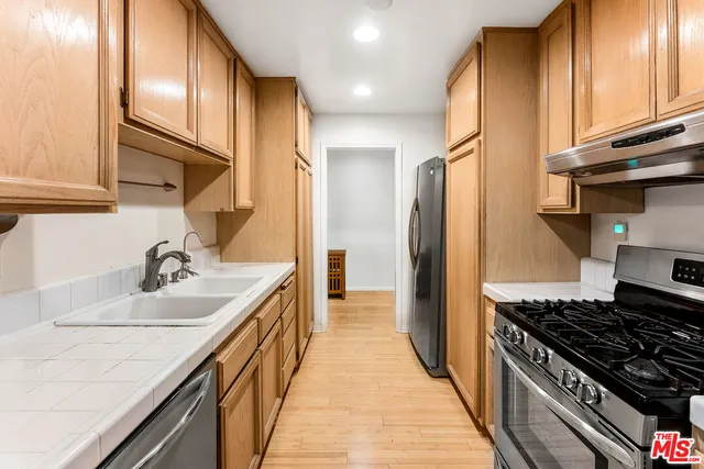 a kitchen with kitchen island granite countertop a sink stove and refrigerator