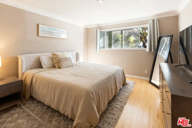 a bed room with a bed window and a flat screen tv