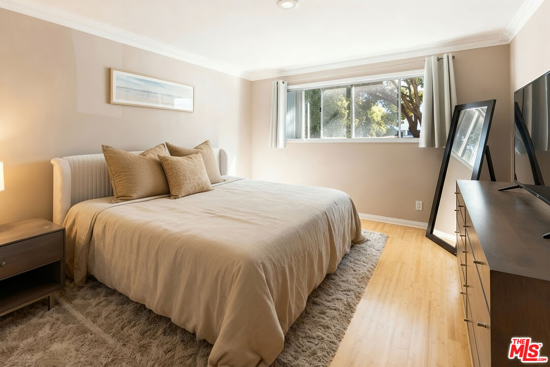 1255 10th Street, Unit 106 Santa Monica, CA 90401 - Photo 10 of 15 a bedroom with a bed and a flat tv screen on a dresser