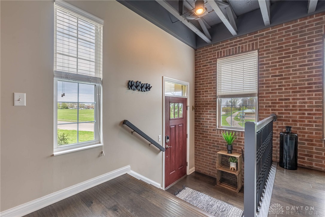 407 Brownstone Row Springboro, OH 45066 - Photo 5 of 54 This inviting entrance features exposed brick and rich hardwood flooring, creating a warm and welcoming atmosphere.