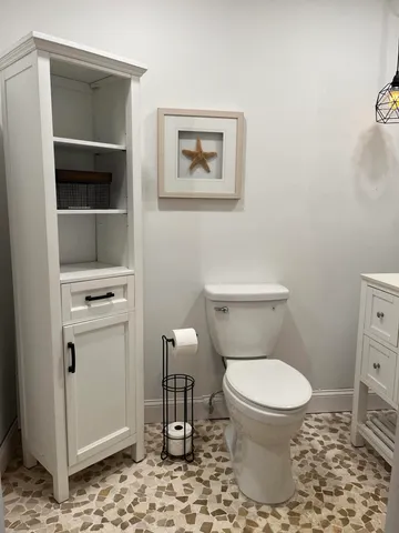 a white toilet sitting next to a bathroom sink