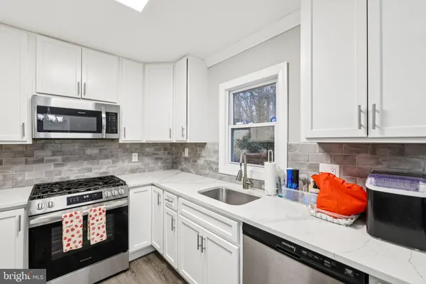 a kitchen with stainless steel appliances a stove microwave and sink