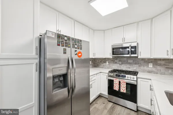 a kitchen with stainless steel appliances and refrigerator