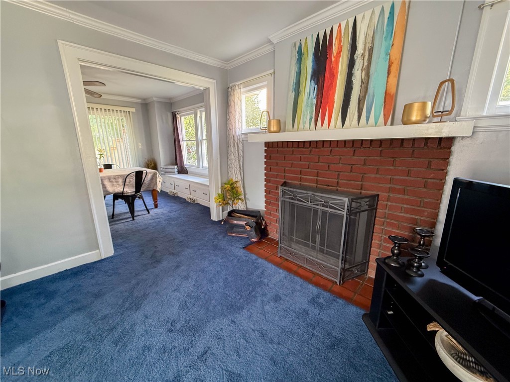 4672 Liberty Road South Euclid, OH 44121 - Photo 4 of 23 Living room with dark colored carpet, ornamental molding, and a brick fireplace