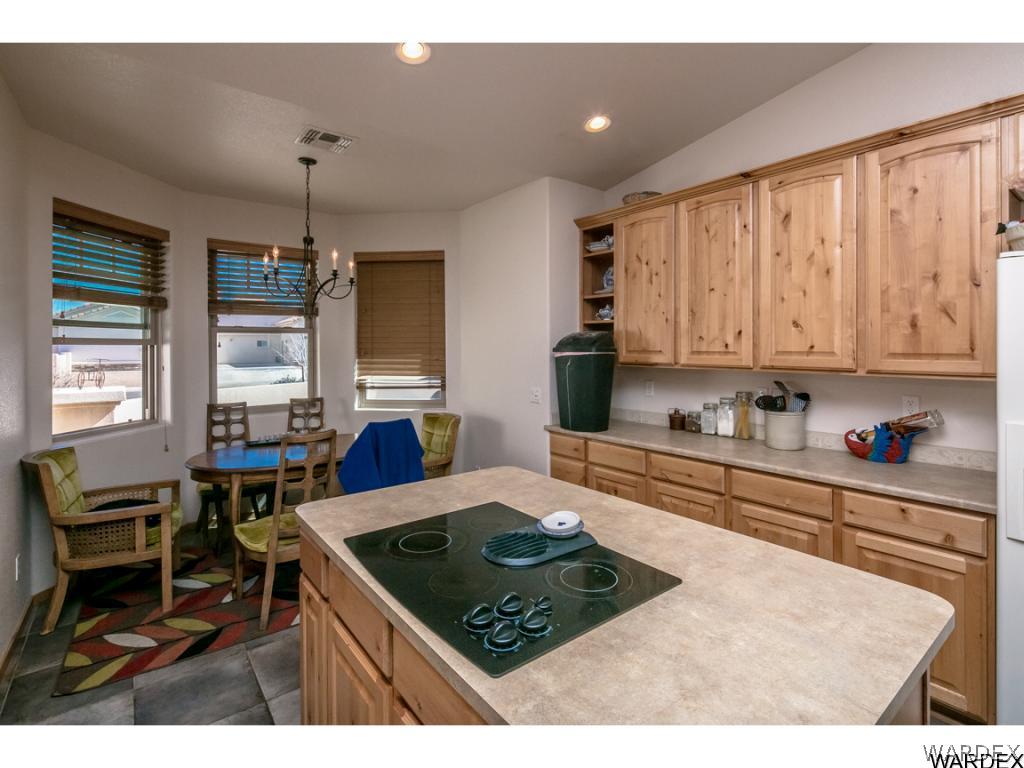 4951 North Neal Ranch Road Kingman, AZ 86401 - Photo 29 of 34 a kitchen with stainless steel appliances granite countertop a stove top oven a sink dishwasher and white cabinets with wooden floor