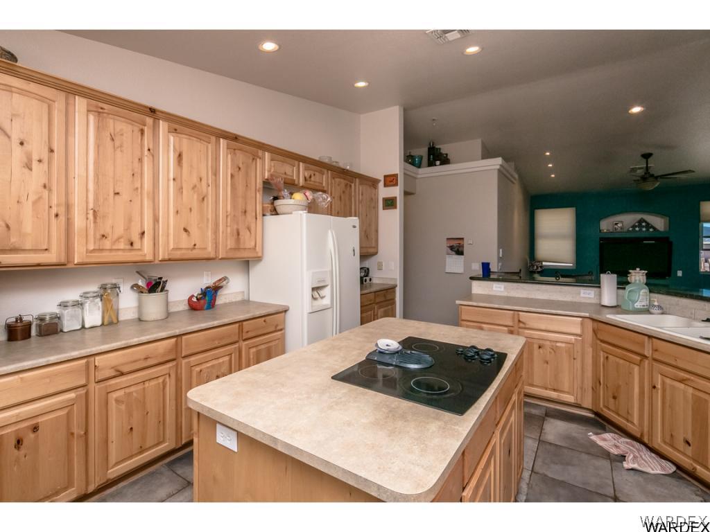 4951 North Neal Ranch Road Kingman, AZ 86401 - Photo 5 of 34 a kitchen with a sink a stove a refrigerator and cabinets