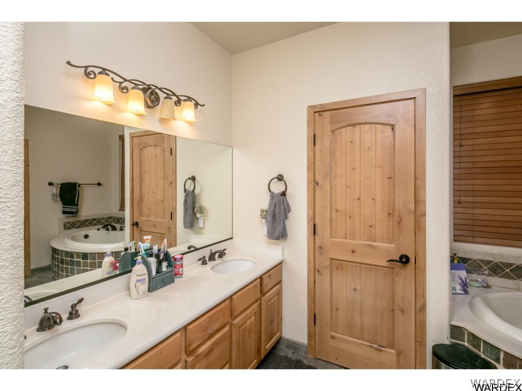 4951 North Neal Ranch Road Kingman, AZ 86401 - Photo 8 of 34 a bathroom with a granite countertop sink vanity mirror and a