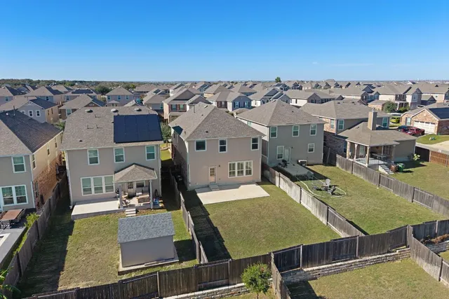 an aerial view of a residential houses with outdoor space and ocean view