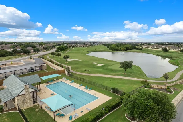 an aerial view of a house with swimming pool garden and patio