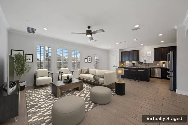 a living room with furniture kitchen view and a large window