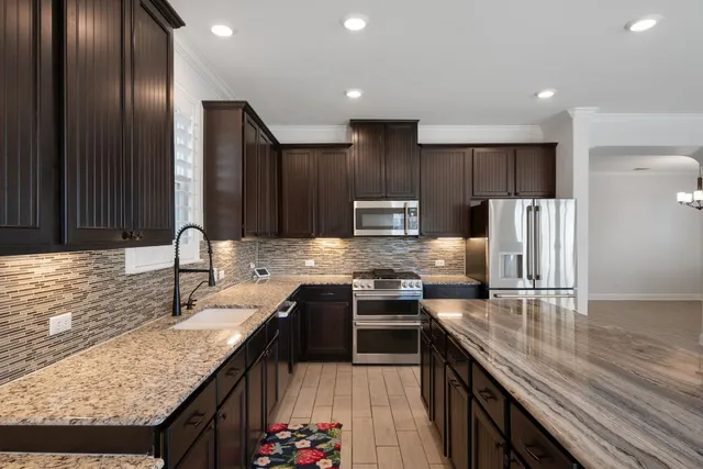 a kitchen with stainless steel appliances granite countertop a sink stove and refrigerator
