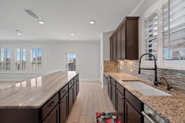 a kitchen with kitchen island granite countertop stainless steel appliances and wooden cabinets