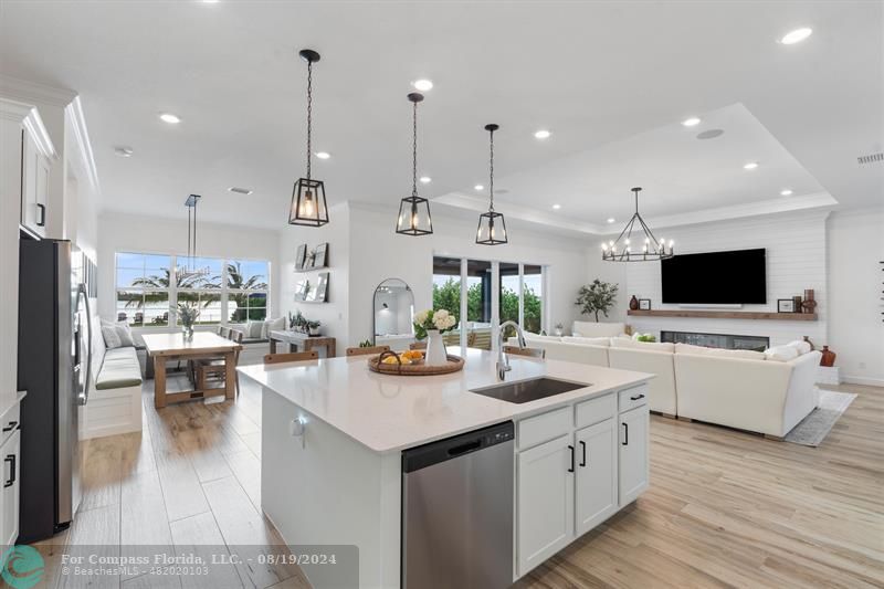 793 Hookline Circle Loxahatchee, FL 33470 - Photo 38 of 80 a open kitchen with stainless steel appliances kitchen island granite countertop a sink dishwasher and a dining table with wooden floor